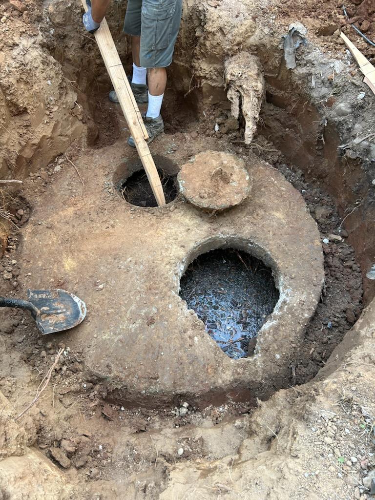 Hand excavated septic tank access in tight backyard space